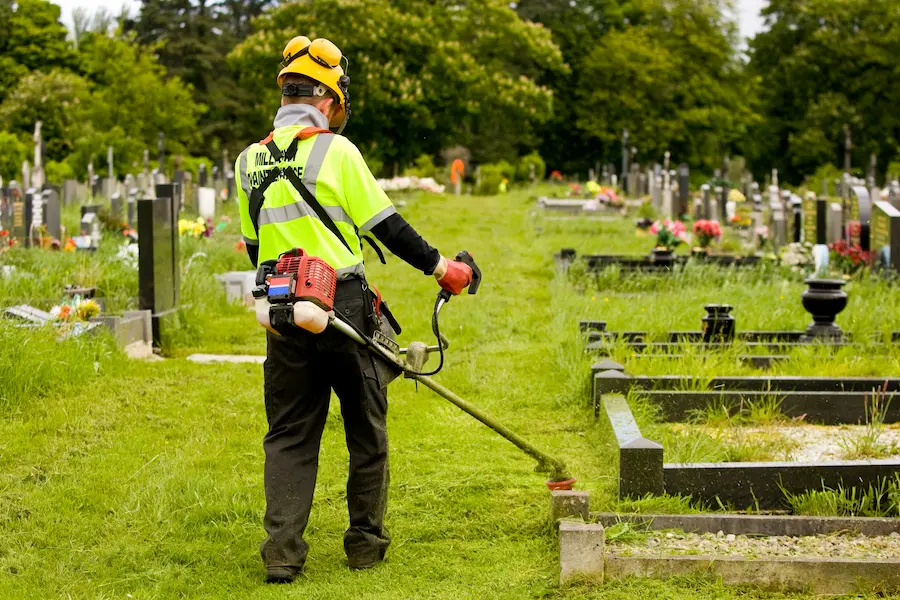 Trimming grass in a graveyard
